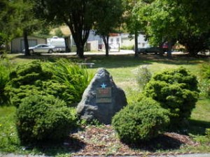 Stone memorial surrounded by shrubs